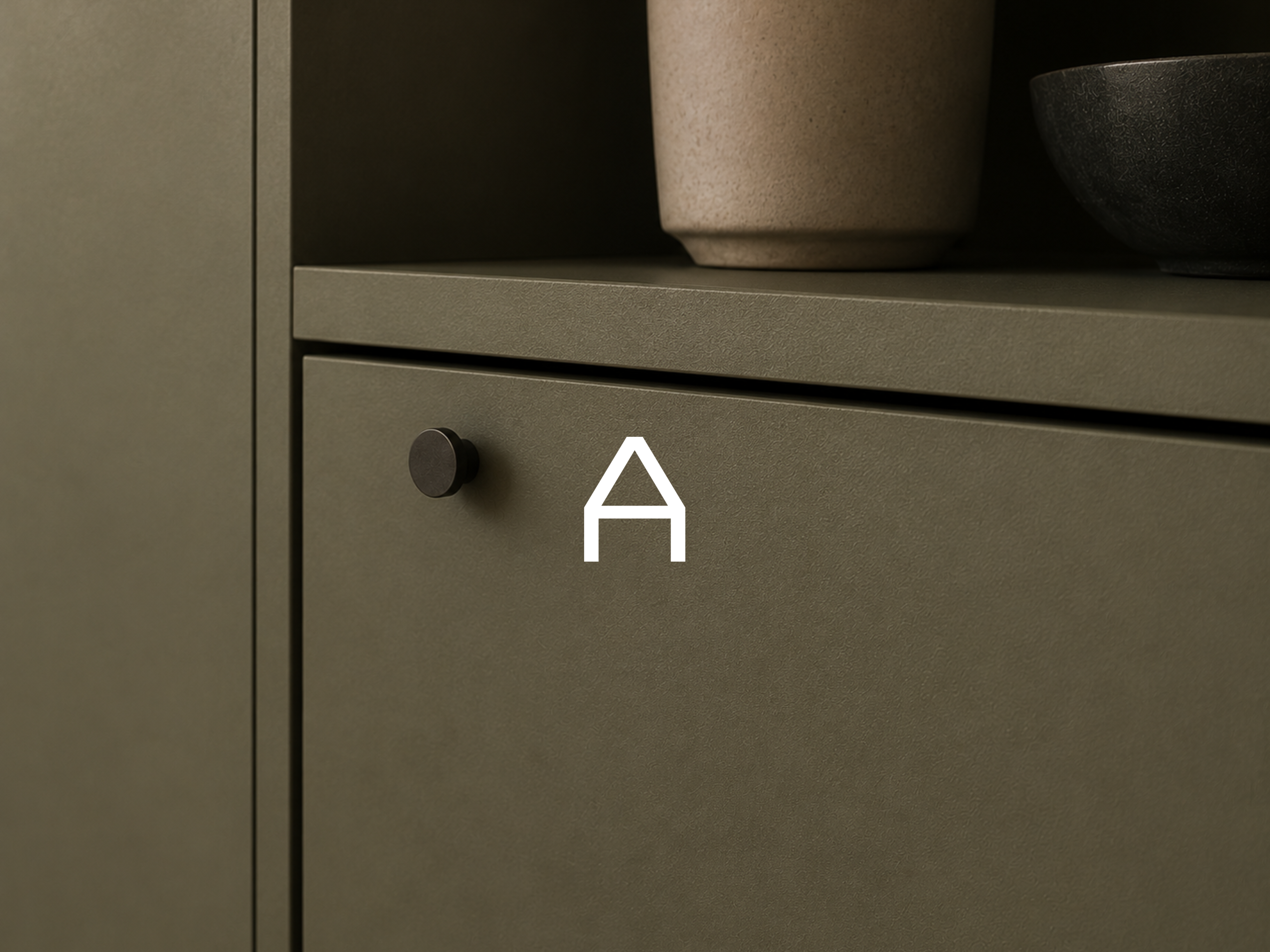 Dunkelgr&uuml;ner Schrank mit Arbio-Logo und dekorativen Vasen