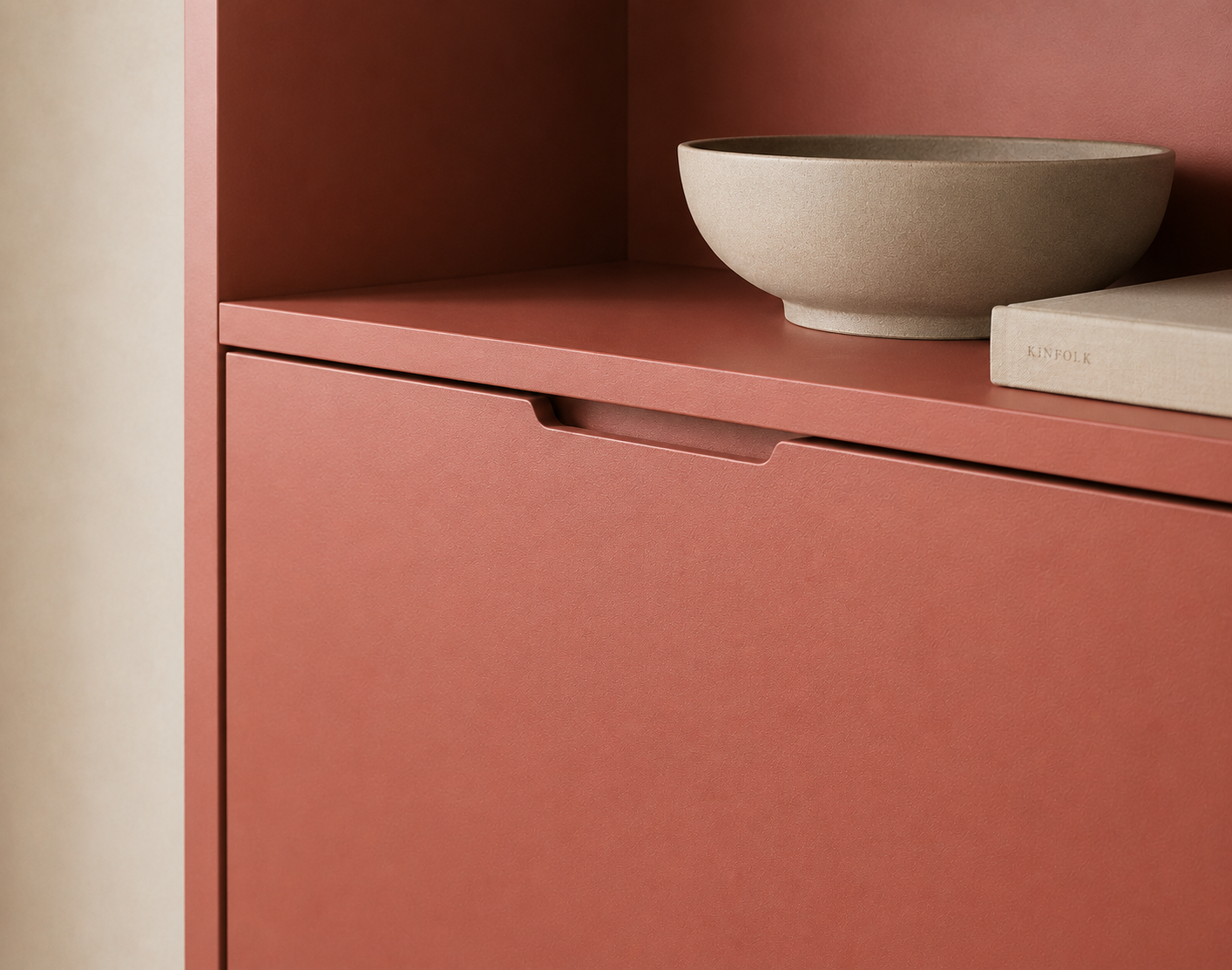Detailaufnahme eines terrakottafarbenen Schranks mit Schale in minimalistischem Interieur
