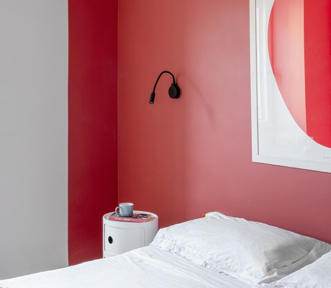 Stilvolles Apartment-Schlafzimmer mit roter Akzentwand und modernem Design